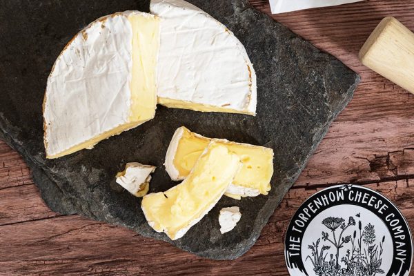 Torpenhow Three Hills Brie, a soft round organic cheese on a slate cheese board