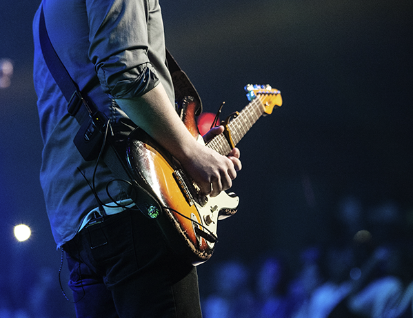 Guitarist playing an electric guitar at a live performance