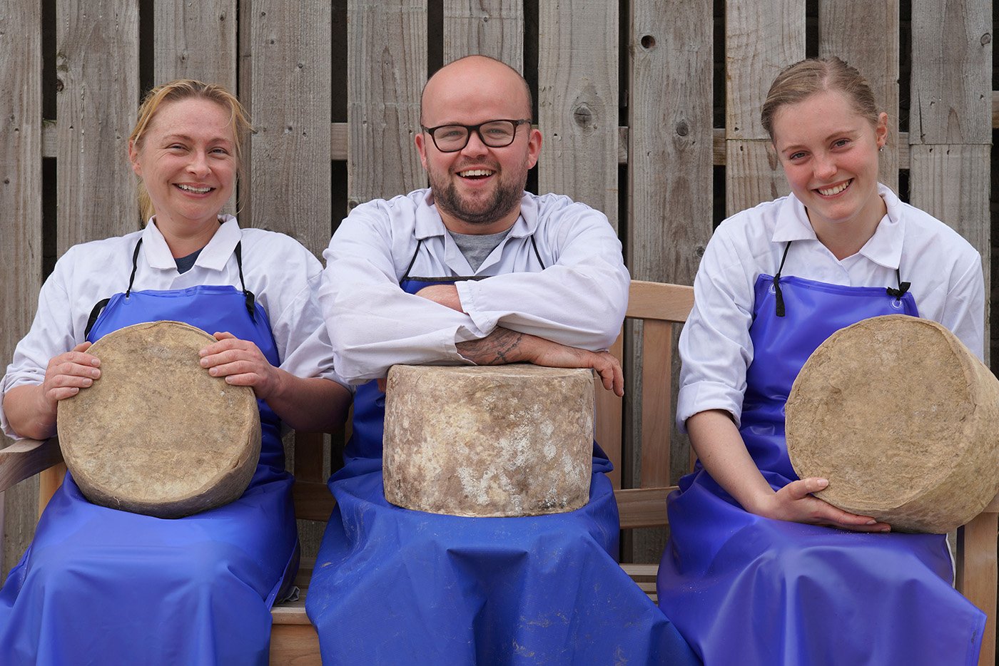 The three award winning cheese makers at Torpenhow, holding rounds of cheese